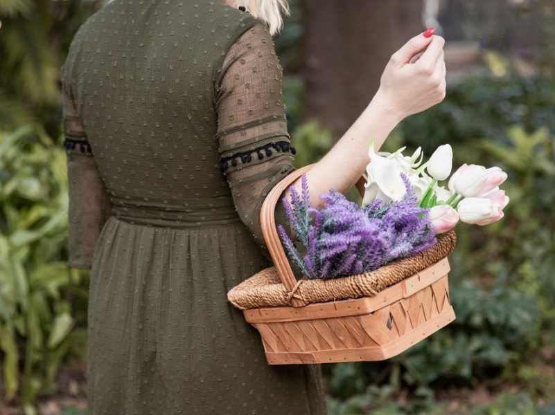 Personne portant un panier en osier rempli de plantes sauvages lors d’une cueillette responsable